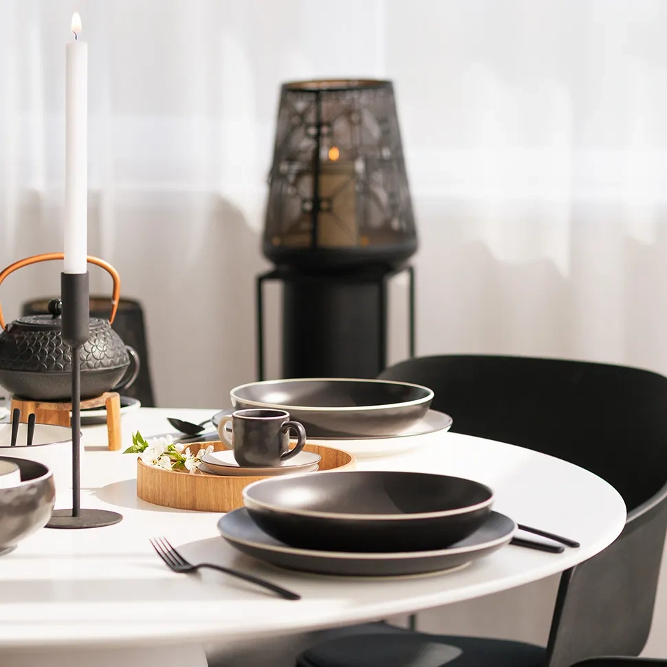 Table dressée avec de la porcelaine noire, une théière et une lanterne
