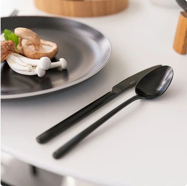 Assiette noire avec de la nourriture et des couverts noirs Calgary